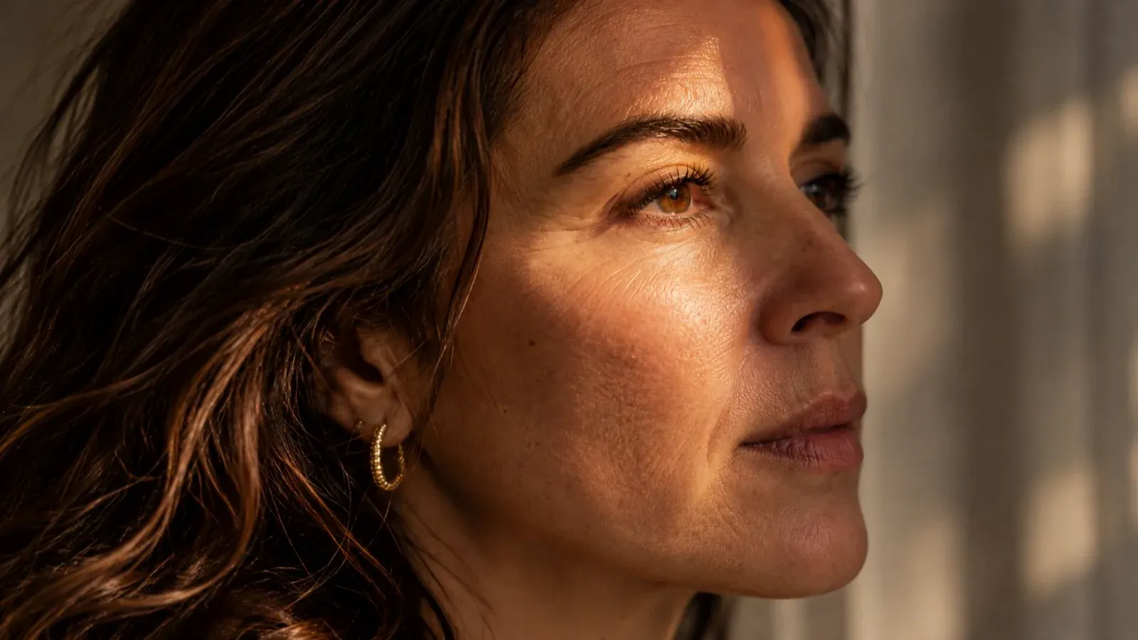 Primer plano del rostro de una mujer con luz cálida; escena ilustrativa.