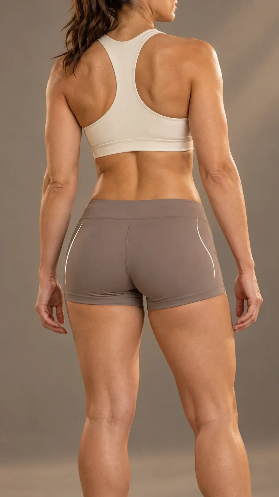 Vista posterior de una mujer con ropa deportiva clara y trazos ilustrativos sobre el contorno de los glúteos.