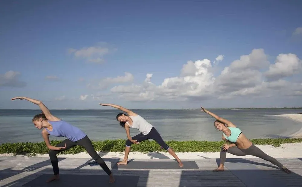 Una clase de yoga en una terraza junto al mar.